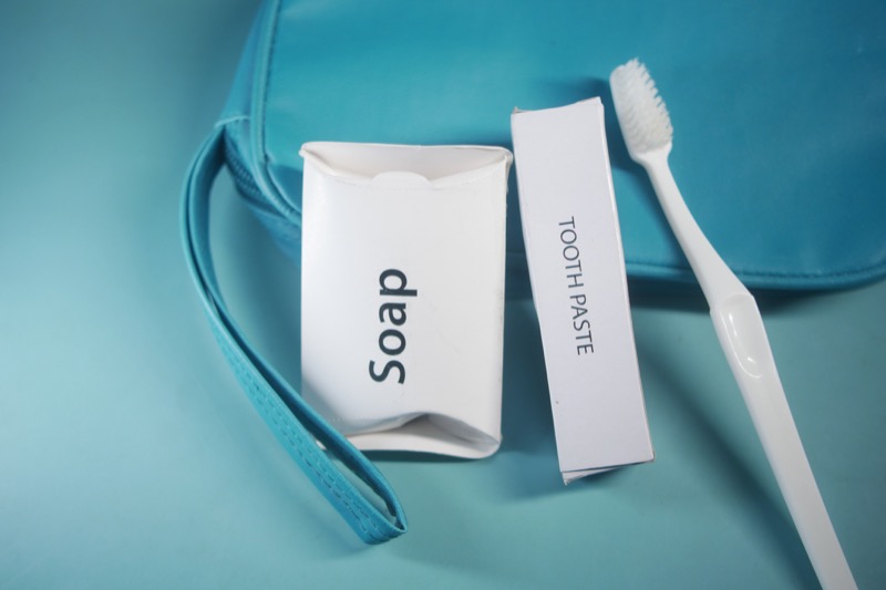 A toiletry kit featuring soap and toothpaste beside a toothbrush.