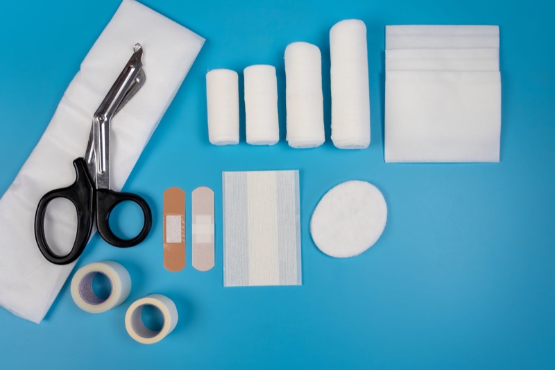 First aid kit against blue colored surface.